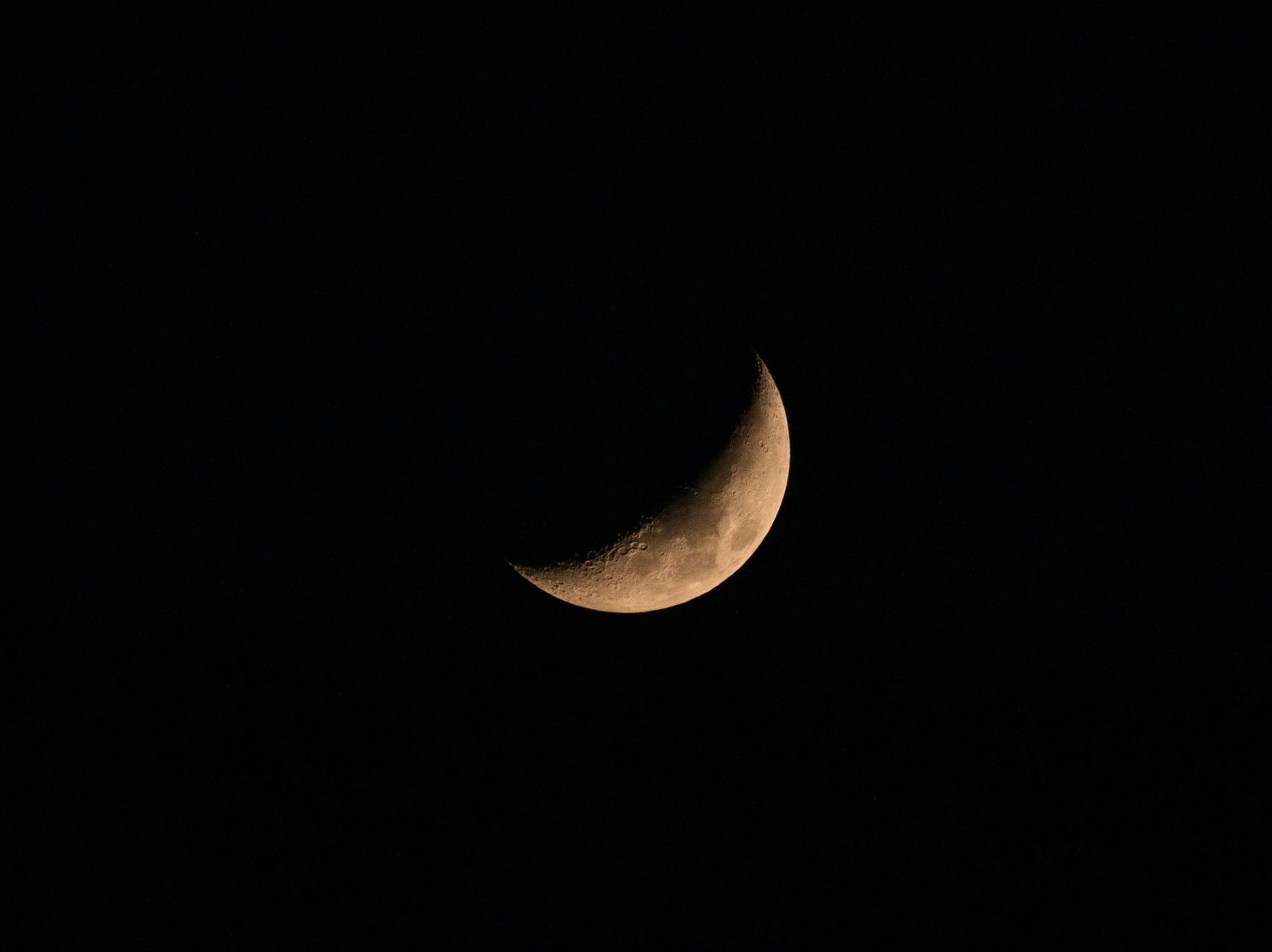 A waxing crescent moon in a black sky